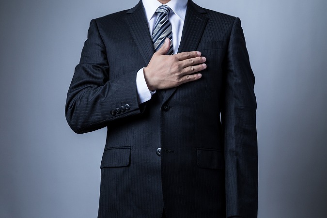 胸に手を当てる男性・スーツ