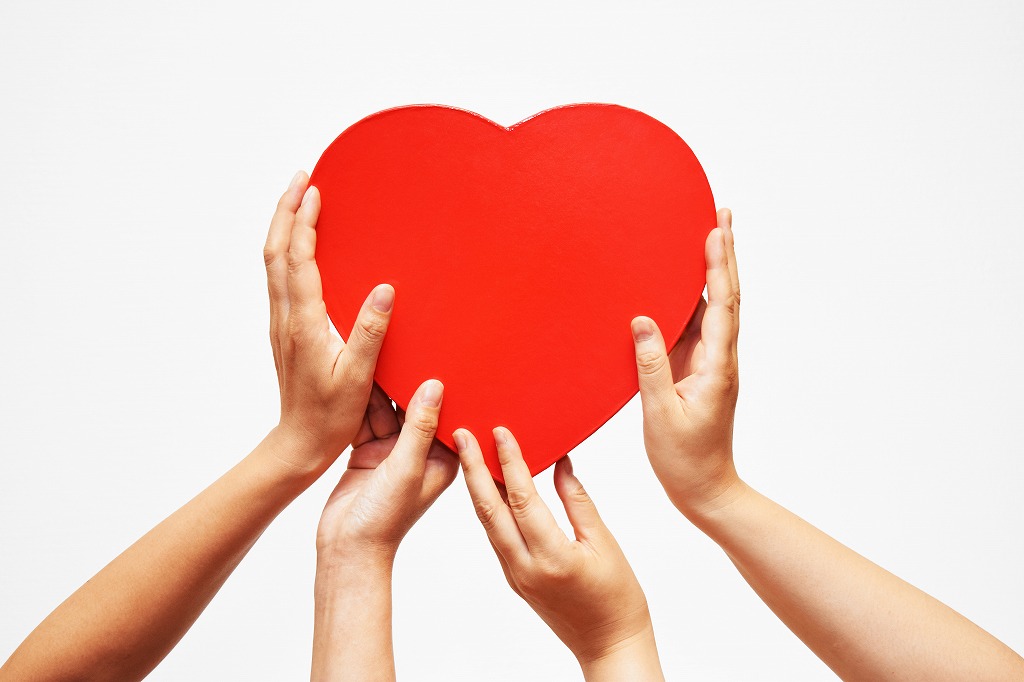 ハートを持つ2人の手